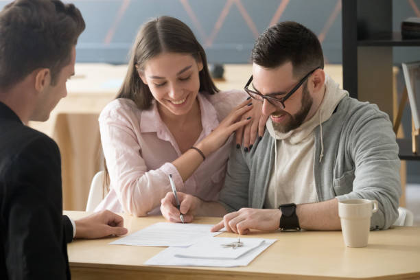 Fotografía ilustrativa de una pareja durante la firma de documentos