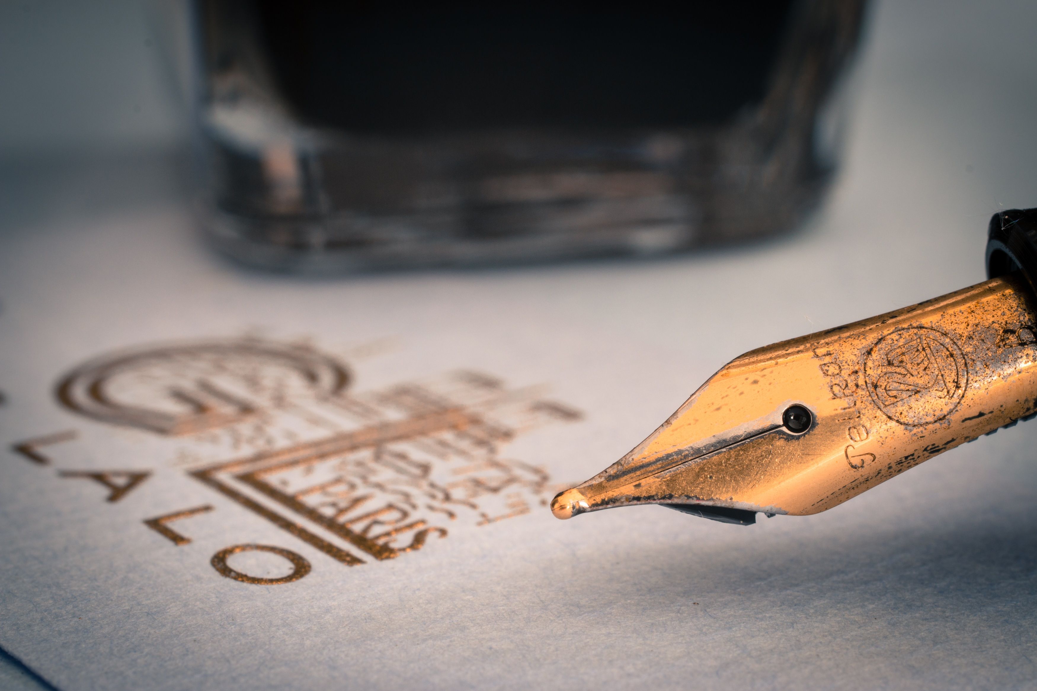 Detalle de una pluma dorada sobre papel